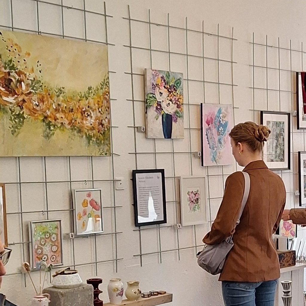 Stemningsbillede fra galleri. En gæst betragter kunstværker